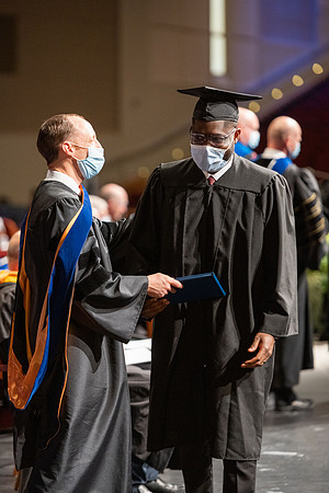 Combined Convocation for the College of Business & Communication and also the College of Physical Sciences & Engineering. Graduates receive their diploma covers.