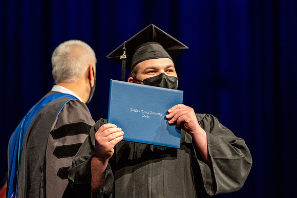 Combined Convocation for the College of Business & Communication and also the College of Physical Sciences & Engineering. Graduates receive their diploma covers.