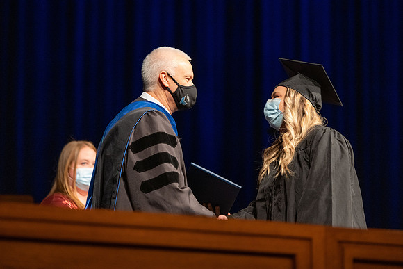 Combined Convocation for the College of Business & Communication and also the College of Physical Sciences & Engineering. Graduates receive their diploma covers.