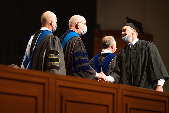 Combined Convocation for the College of Business & Communication and also the College of Physical Sciences & Engineering. Graduates receive their diploma covers.