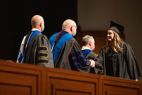 Combined Convocation for the College of Business & Communication and also the College of Physical Sciences & Engineering. Graduates receive their diploma covers.