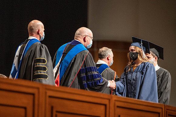 Combined Convocation for the College of Business & Communication and also the College of Physical Sciences & Engineering. Graduates receive their diploma covers.