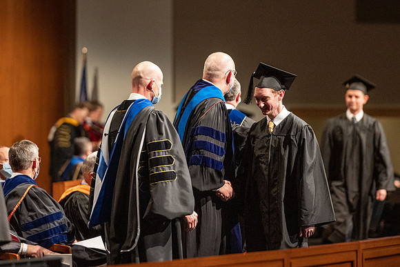 Combined Convocation for the College of Business & Communication and also the College of Physical Sciences & Engineering. Graduates receive their diploma covers.