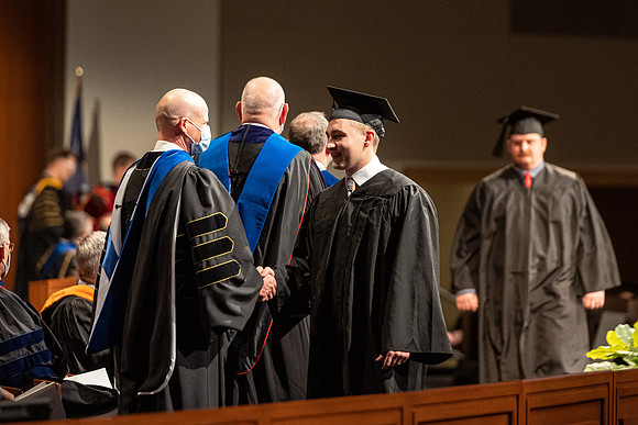 Combined Convocation for the College of Business & Communication and also the College of Physical Sciences & Engineering. Graduates receive their diploma covers.