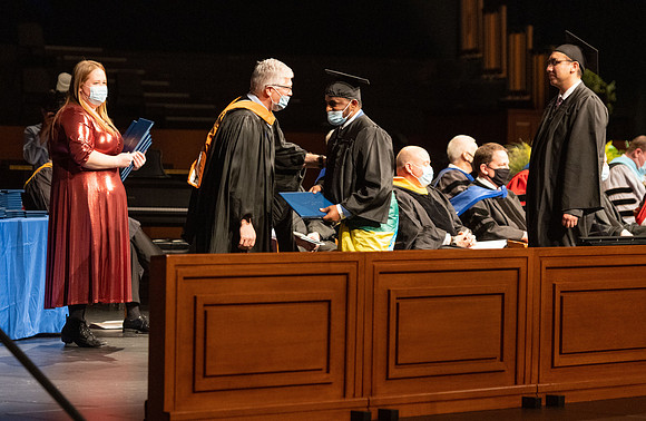 Combined Convocation for the College of Business & Communication and also the College of Physical Sciences & Engineering. Graduates receive their diploma covers.