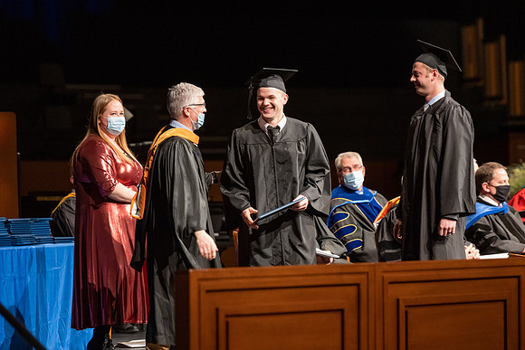 Combined Convocation for the College of Business & Communication and also the College of Physical Sciences & Engineering. Graduates receive their diploma covers.