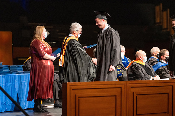 Combined Convocation for the College of Business & Communication and also the College of Physical Sciences & Engineering. Graduates receive their diploma covers.