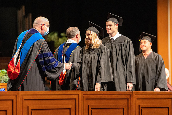 Combined Convocation for the College of Business & Communication and also the College of Physical Sciences & Engineering. Graduates receive their diploma covers.
