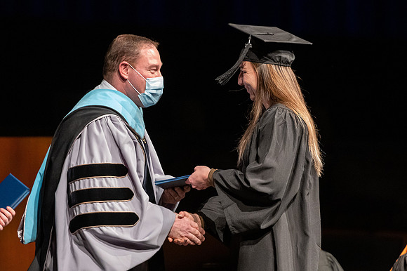 Combined Convocation for the College of Business & Communication and also the College of Physical Sciences & Engineering. Graduates receive their diploma covers.
