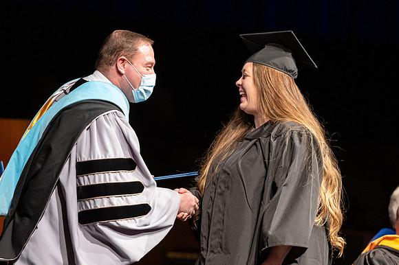 Combined Convocation for the College of Business & Communication and also the College of Physical Sciences & Engineering. Graduates receive their diploma covers.