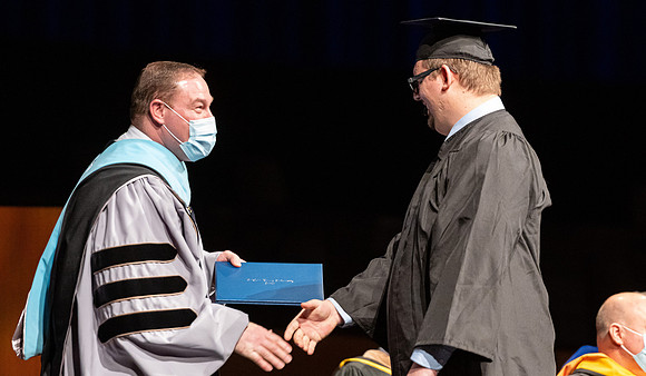 Combined Convocation for the College of Business & Communication and also the College of Physical Sciences & Engineering. Graduates receive their diploma covers.