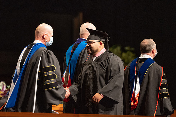 Combined Convocation for the College of Business & Communication and also the College of Physical Sciences & Engineering. Graduates receive their diploma covers.
