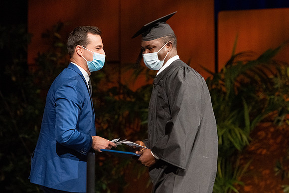 Combined Convocation for the College of Business & Communication and also the College of Physical Sciences & Engineering. Graduates receive their diploma covers.