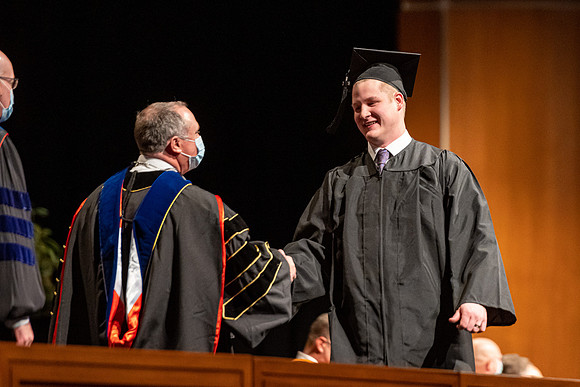 Combined Convocation for the College of Business & Communication and also the College of Physical Sciences & Engineering. Graduates receive their diploma covers.
