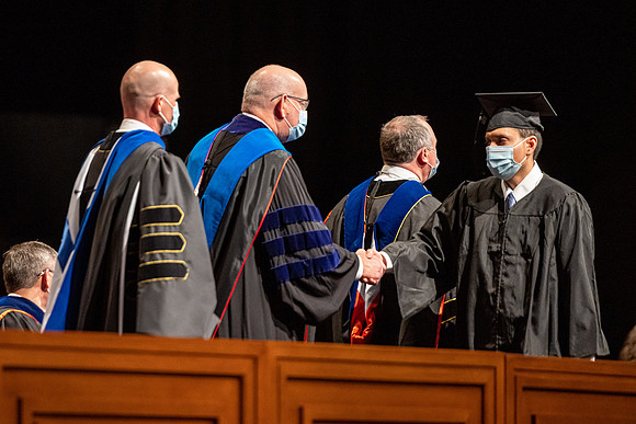 Combined Convocation for the College of Business & Communication and also the College of Physical Sciences & Engineering. Graduates receive their diploma covers.
