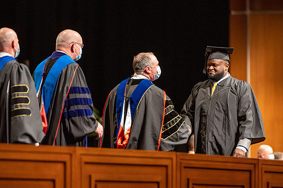 Combined Convocation for the College of Business & Communication and also the College of Physical Sciences & Engineering. Graduates receive their diploma covers.