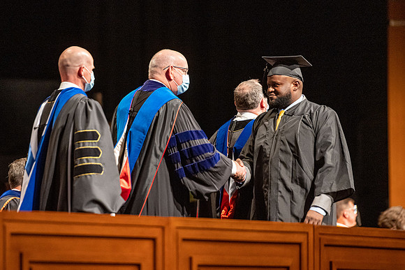 Combined Convocation for the College of Business & Communication and also the College of Physical Sciences & Engineering. Graduates receive their diploma covers.