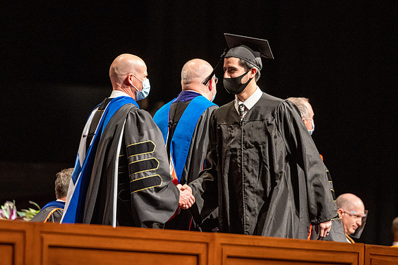 Combined Convocation for the College of Business & Communication and also the College of Physical Sciences & Engineering. Graduates receive their diploma covers.