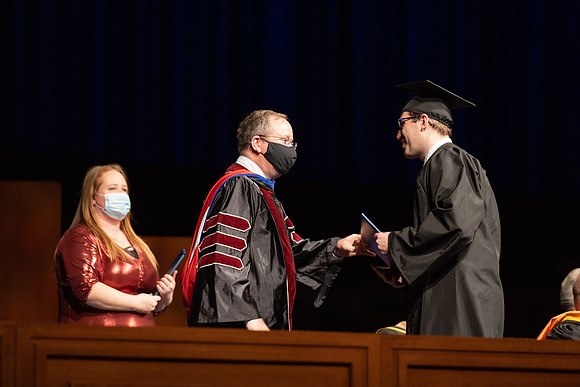 Combined Convocation for the College of Business & Communication and also the College of Physical Sciences & Engineering. Graduates receive their diploma covers.