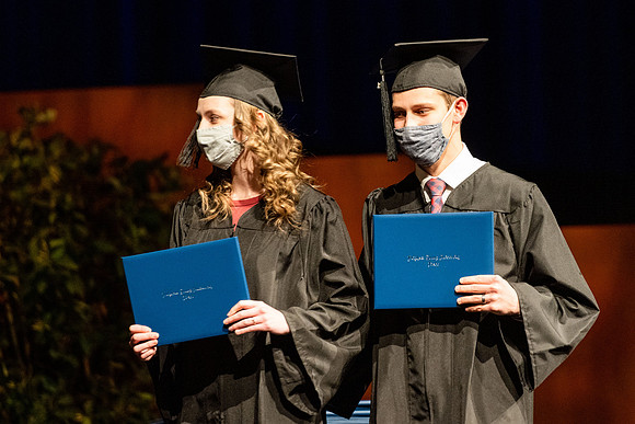 Combined Convocation for the College of Business & Communication and also the College of Physical Sciences & Engineering. Graduates receive their diploma covers.