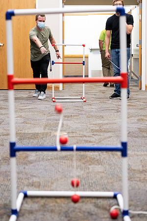 Students socialize and play games together while taking necessary safety precautions.