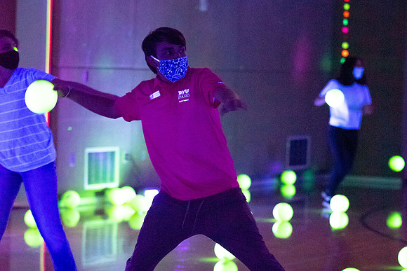 Examples of students staying safe and healthy during the COVID-19 pandemic by social distancing, following pathway arrows, and wearing face masks during activities.