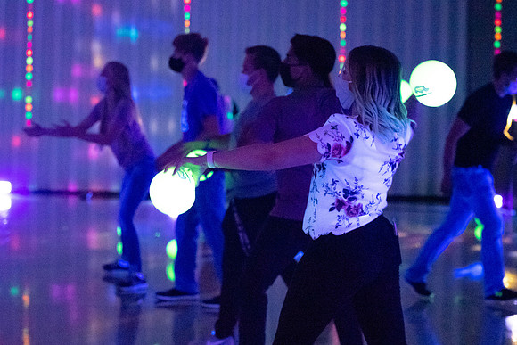 Examples of students staying safe and healthy during the COVID-19 pandemic by social distancing, following pathway arrows, and wearing face masks during activities.