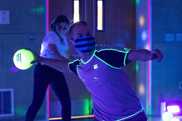 Examples of students staying safe and healthy during the COVID-19 pandemic by social distancing, following pathway arrows, and wearing face masks during activities.