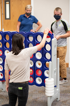 Examples of students staying safe and healthy during the COVID-19 pandemic by social distancing, following pathway arrows, and wearing face masks during activities.