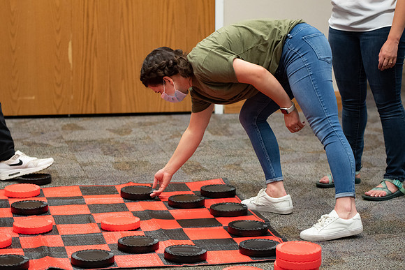 Examples of students staying safe and healthy during the COVID-19 pandemic by social distancing, following pathway arrows, and wearing face masks during activities.