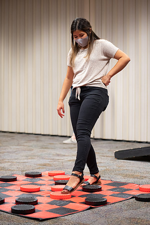 Examples of students staying safe and healthy during the COVID-19 pandemic by social distancing, following pathway arrows, and wearing face masks during activities.