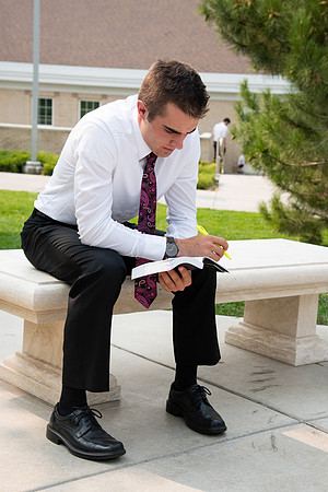 Student reading scriptures on the temple grounds.