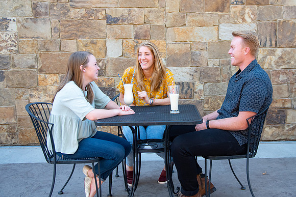 Students off campus wearing face masks and drinking a milkshake.