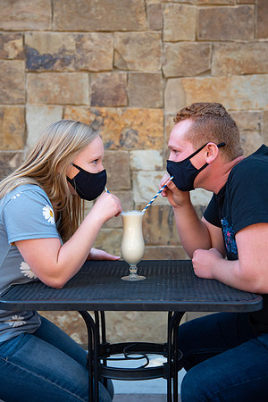 Students off campus wearing face masks and drinking a milkshake.