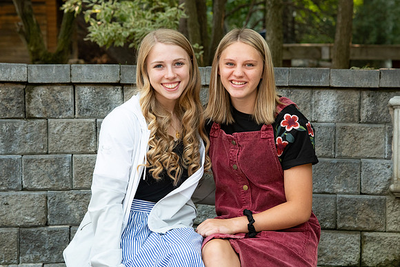 Students smiling at the camera in the Thomas E. Ricks gardens after church on a Sunday.