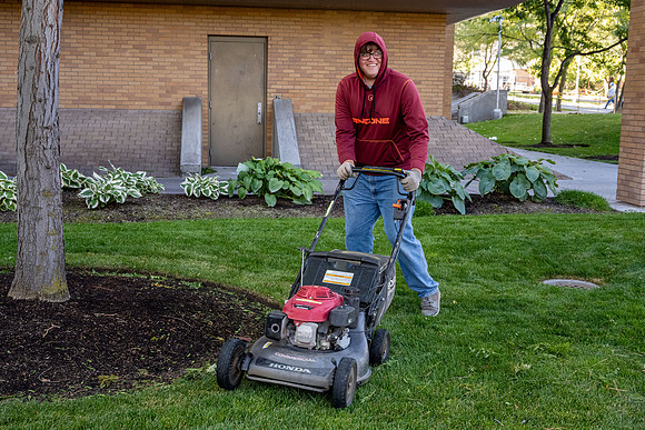 Jorge Bobadilla Rios getting the job done. Mowing the grounds around the Romney Building.