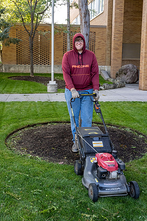 Jorge Bobadilla Rios getting the job done. Mowing the grounds around the Romney Building.