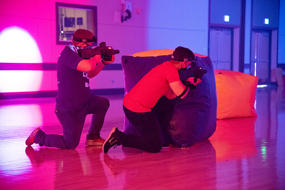 Students play laser tag on campus with masks on.