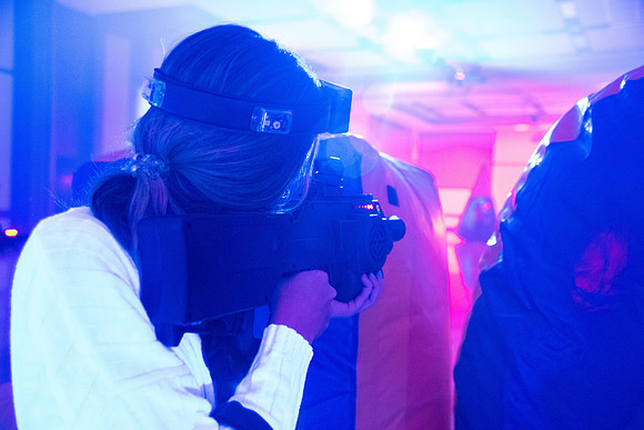 Students play laser tag on campus with masks on.