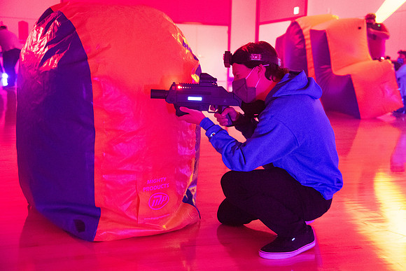 Students play laser tag on campus with masks on.