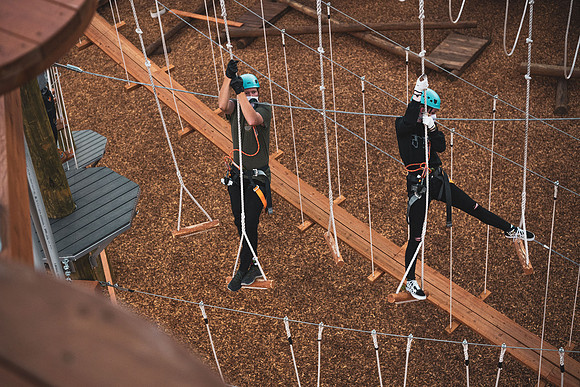 Students navigate the BYU-Idaho ropes course while taking social distancing precautions and wearing masks.