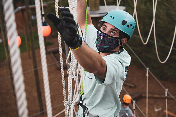 Students navigate the BYU-Idaho ropes course while taking social distancing precautions and wearing masks.