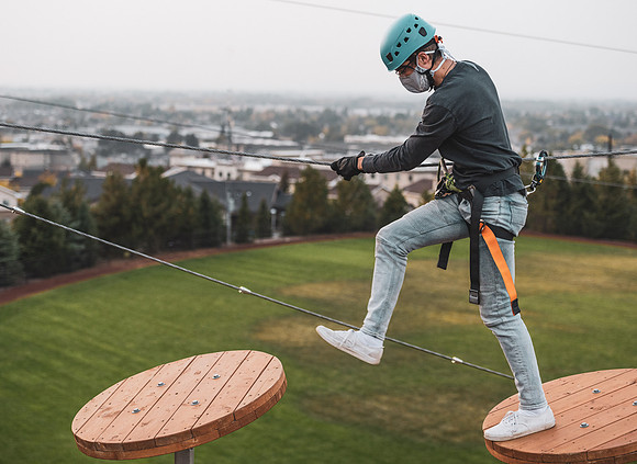 Students navigate the BYU-Idaho ropes course while taking social distancing precautions and wearing masks.