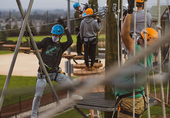 Students navigate the BYU-Idaho ropes course while taking social distancing precautions and wearing masks.