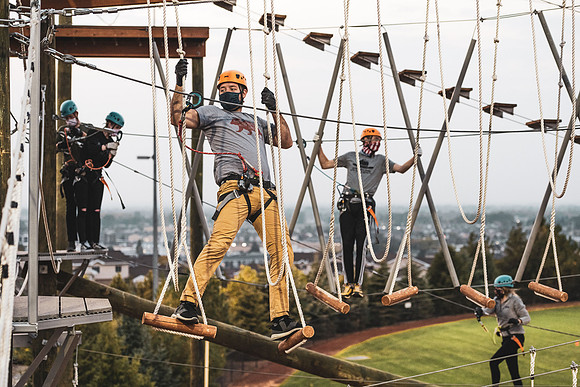 Students navigate the BYU-Idaho ropes course while taking social distancing precautions and wearing masks.