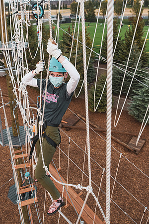Students navigate the BYU-Idaho ropes course while taking social distancing precautions and wearing masks.