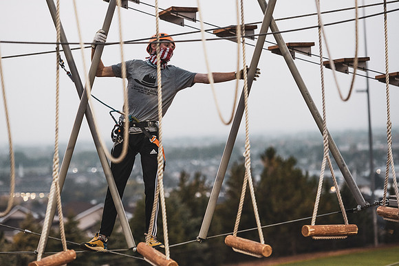 Students navigate the BYU-Idaho ropes course while taking social distancing precautions and wearing masks.