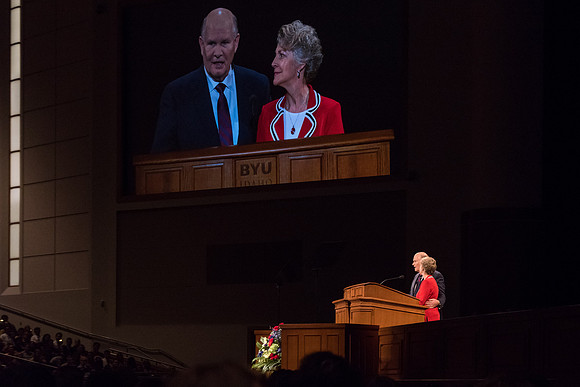 Elder Renlund and Sister Renlund stand together and speak at BYUI devotional. Photo by Garrett Blanchard