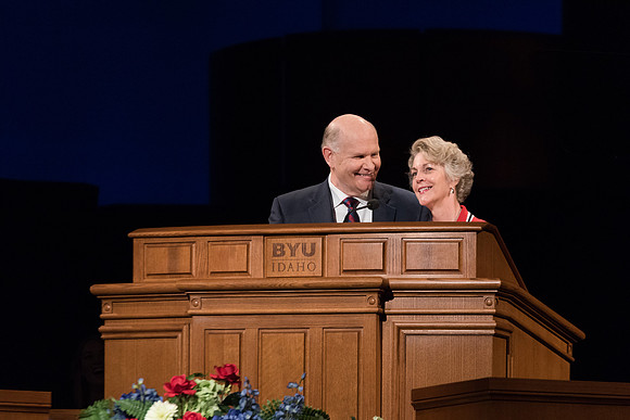 Elder Renlund and Sister Renlund stand together and speak at BYUI devotional. Photo by Garrett Blanchard