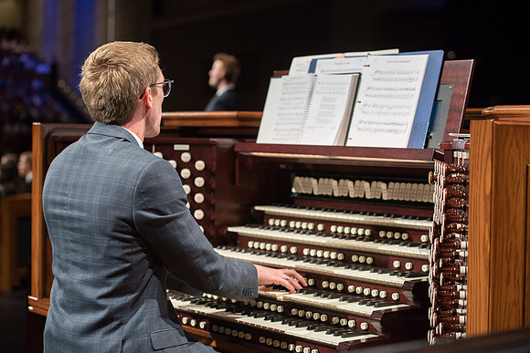 Student organist plays for the opening hymn during devotional.
